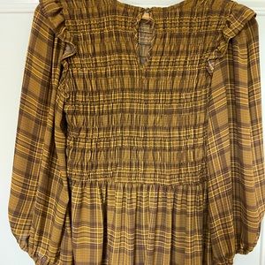 Brown plaid blouse with elastic waistband and ruffle underneath it
